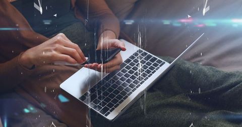 Woman using smartphone with laptop on cityscape background