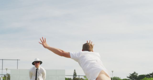 Cricketer Bowling Action with Umpire in Background on Sunny Day - Download Free Stock Images Pikwizard.com