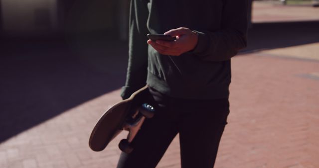 Urban Lifestyle: Skateboarder Checking Smartphone Outdoors - Download Free Stock Images Pikwizard.com