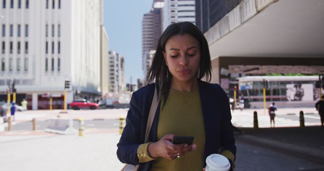 Focused Mixed-Race Businesswoman Texting and Walking in Financial District - Download Free Stock Images Pikwizard.com