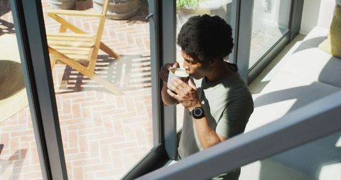 Relaxed African American Man Enjoying Morning Coffee by Window