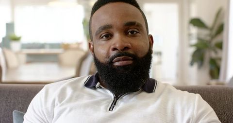 Confident Man Relaxing in Modern Minimalist Living Room