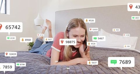 Young woman lying on bed using smartphone with social media notification overlays, smiling