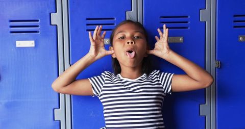 Playful Young Girl Making Fun Face in School Hallway