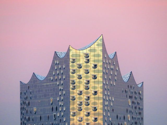 Modern Architectural Building with Unique Roof Design against a Pink Sky - Download Free Stock Photos Pikwizard.com