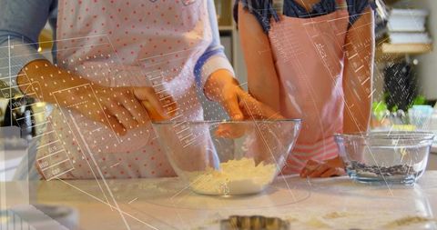 Parent and child mixing dough in kitchen teaching baking skills and family bonding