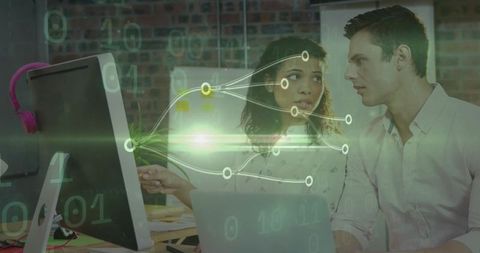 Colleagues analyzing data and codes collaboratively in modern office