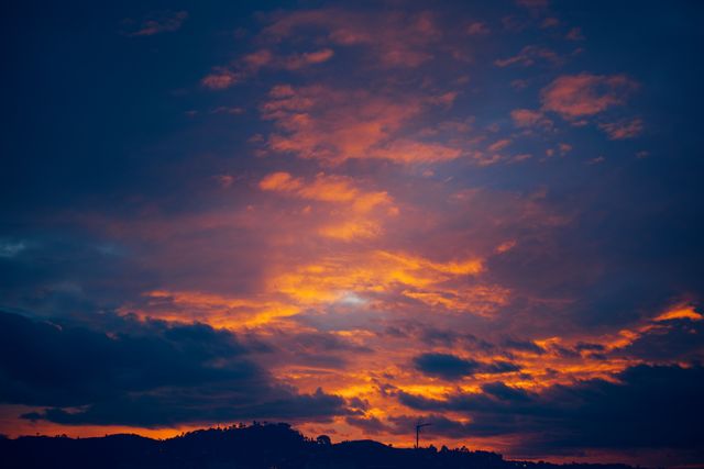 Vibrant Sunset Sky with Dramatic Clouds Over Hills - Download Free Stock Photos Pikwizard.com