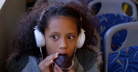 Girl Enjoying Muffin While Traveling on Bus