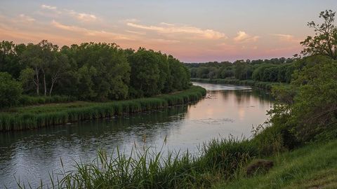 Serene meandering river at sunset with lush greenery