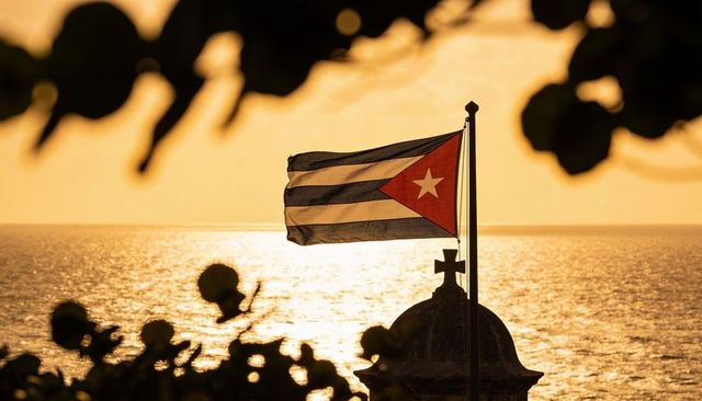 Cuban flag waving over seaside turret at golden sunset glow