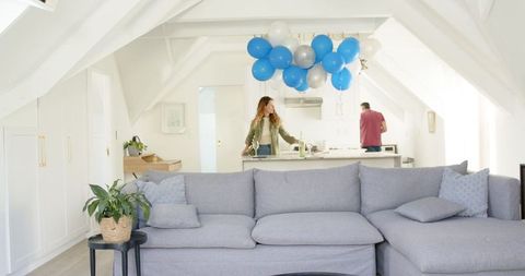 Happy Couple Celebrating at Home with Balloons and Smiles
