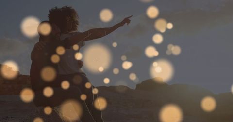 Couple Embracing at Seaside with Dreamy Bokeh Lights