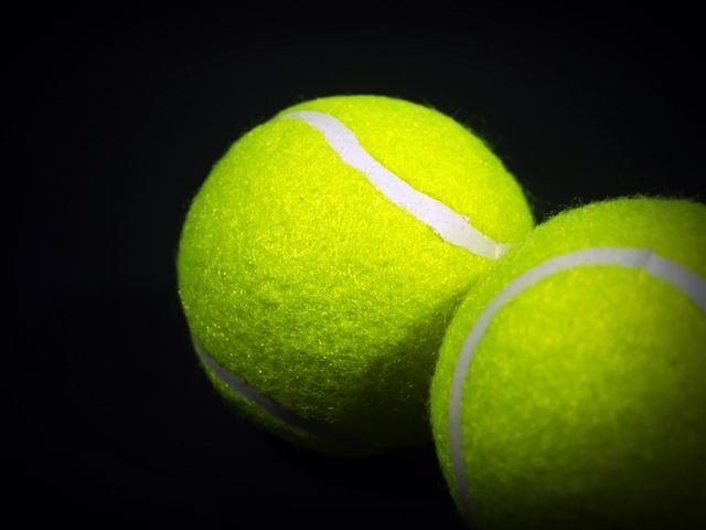 Close-Up of Tennis Balls with Yellow Felt Against Black Background - Download Free Stock Images Pikwizard.com