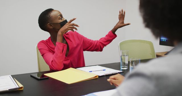 Image depicts a female entrepreneur engaged in an interactive business meeting. Ideal for use in articles about business strategies, professional communication, and workplace safety measures during the pandemic. Can be used for corporate training materials, blog posts on leadership, or marketing materials for business consultations and seminars.