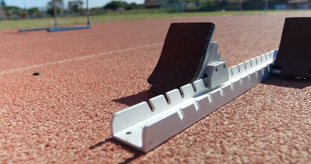 Close-up of starting blocks on a running track. Hurdles arranged in the background 4k