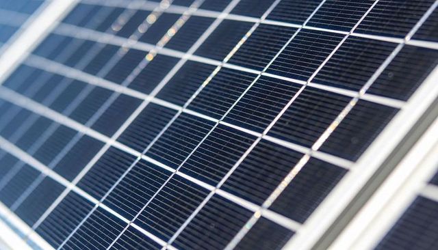 Angled Photovoltaic Solar Panel Closeup Reflecting Sunlight with Metallic Busbars