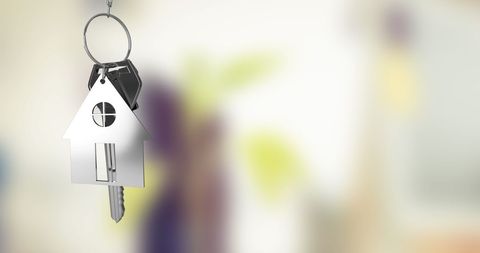 House shaped keychain indoors symbolizing home ownership