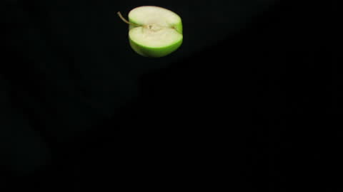 Floating Green Apple Slice Against Dark Background