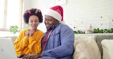 African American Father and Daughter Shopping Online Wearing Santa Hat and Reindeer Headband