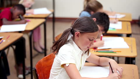 Focused Students Writing at Classroom Desks