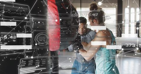 Woman punching heavy bag with coach holding bag and futuristic hud training overlay
