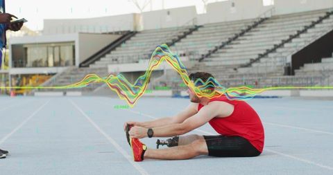 Adaptive runner stretching on track with carbon blade prosthetic while coach monitoring data