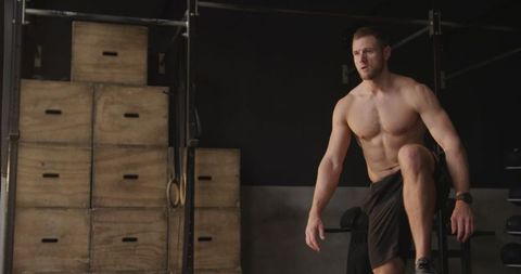 Fit male athlete cross training with box jumps in gym