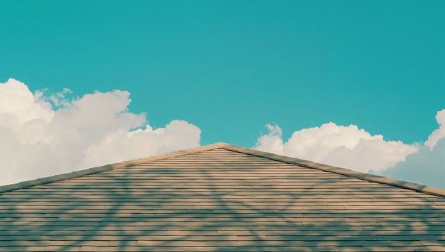 Triangular Roof with Asphalt Shingles Under Clear Blue Sky