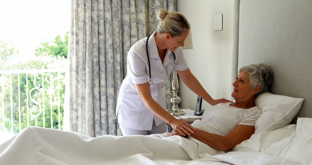 Nurse attending to elderly woman in bed at home showcases the importance of in-home healthcare support. Useful for topics related to elderly care, nursing, home healthcare services, caregiving, and patient support.