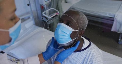 Doctor examining masked patient on hospital bed wearing gloves and ppe with clinical monitor