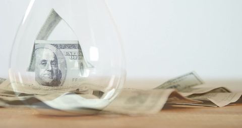 Hourglass enclosing banknotes represents time and money value