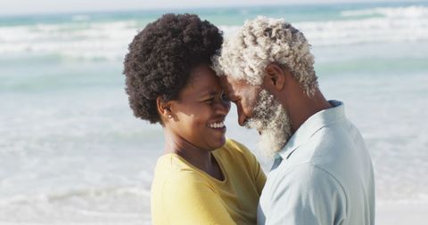 Joyful Senior Couple Embracing at Beachside on Sunny Day