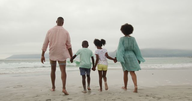 Family Strolling Along Beach during Cloudy Day - Download Free Stock Images Pikwizard.com