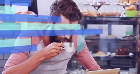 Bearded man sipping coffee while tapping tablet with floating analytics overlays in cafe