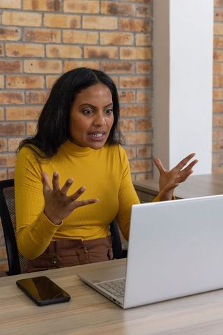 Frustrated woman discussing online work issue in office