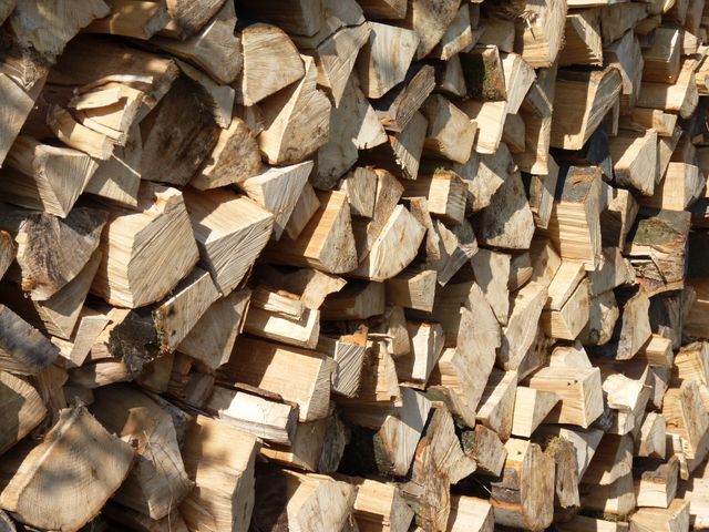 Closeup of a stack of chopped firewood arranged neatly. Ideal for illustrating rustic living, sustainability, use of natural fuel, heating, DIY projects or forestry topics.