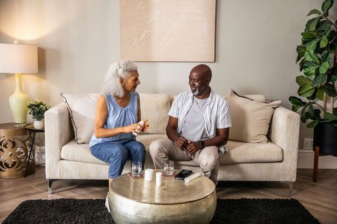 Senior Couple Discussing Wellness on Sofa in Modern Living Room