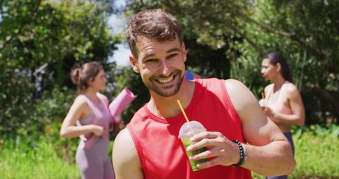 Man Enjoying Health Drink with Friends After Yoga in Sunny Park - Download Free Stock Images Pikwizard.com