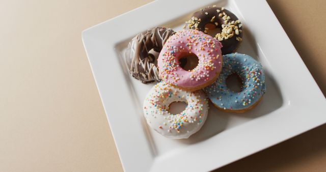 Variety of frosted donuts with sprinkles on white plate - Download Free Stock Images Pikwizard.com