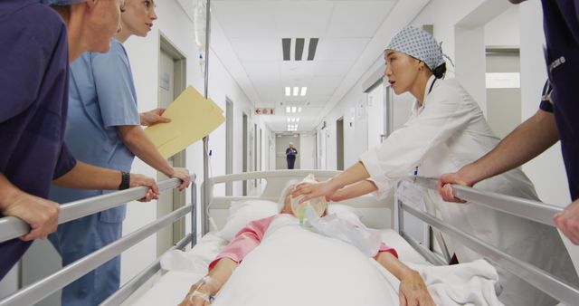 Image of diverse group of medical workers moving patient on ventilator down hospital corridor in bed. Hospital, medical and healthcare services.
