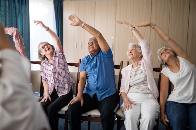 Smiling senior people stretching with female doctor at retirement home
