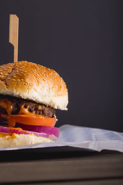 Close-up of burger on table against gray background with copy space. unaltered, food, fried food, studio shot, unhealthy eating and snack.