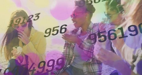 Laughing friends on sunny beach enjoying snacks and conversation with numeric bokeh