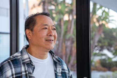 Asian Man Enjoying Peaceful Garden View Through Sliding Door
