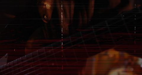 Closeup guitarist hand fretting steel strings with red scanlines, low light grainy mood