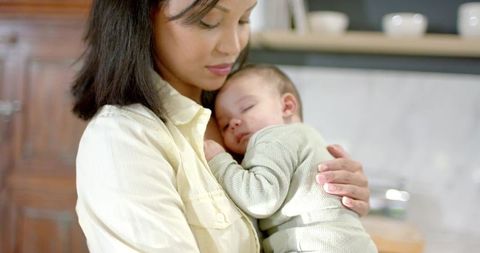Mother embracing sleepy baby for tender nap moment