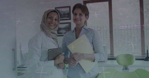 Diverse Female Dentists Discuss Patient Care Plan in Modern Clinic