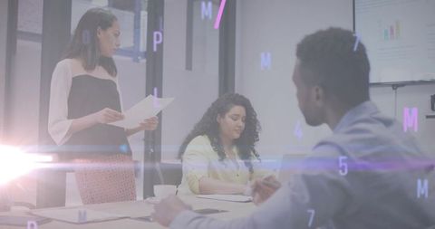 Business team collaborating during data presentation with seated participant taking notes