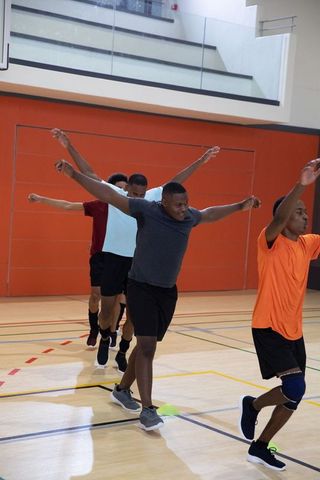 African american men performing agility drill on indoor court for basketball training